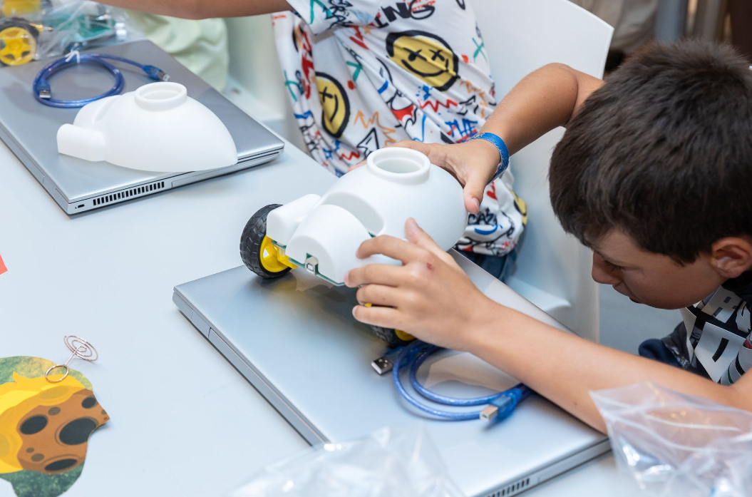 Niño arma un robot móvil durante un taller STEAM de la Fundación REBDI