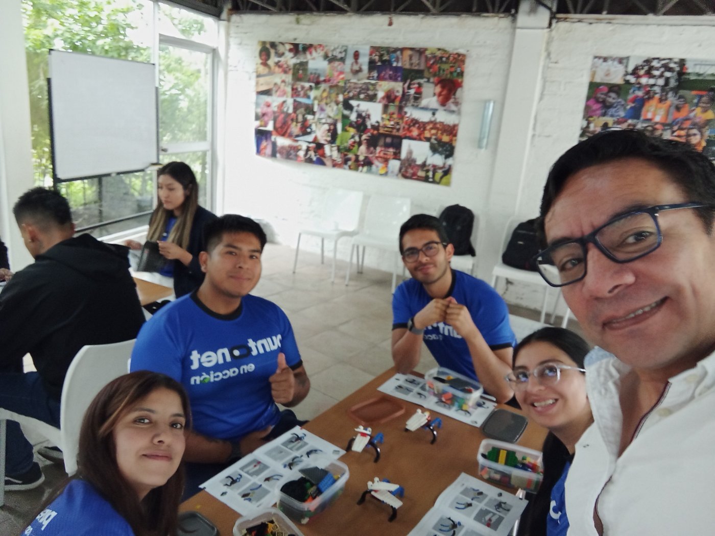 Grupo de voluntarios sonríe junto al facilitador durante el taller de identidad voluntaria